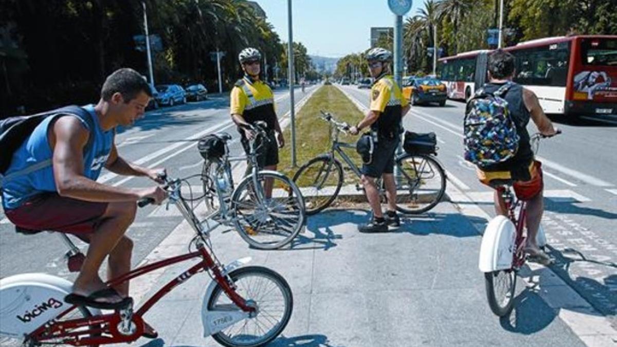 Dos agentes de la patrulla ciclista de la Guardia Urbana custodian el carril bici de la calle de la Marina, el pasado miércoles.