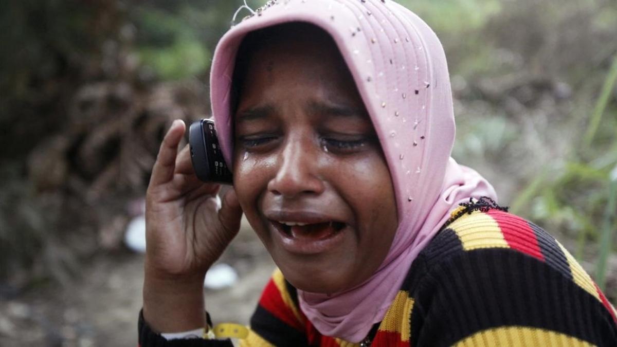 Una refugiada rohingya llora mientras habla por teléfono con su hermano.