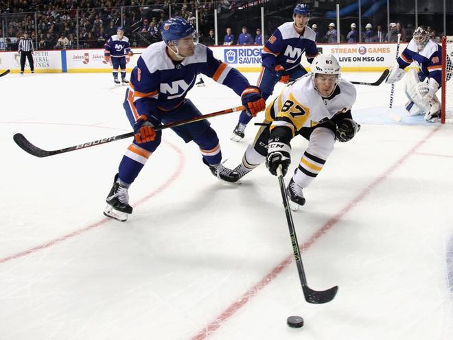 Sidney Crosby # 87 de los Pittsburgh Penguins lleva el disco contra Ryan Pulock # 6 de los New York Islanders en el Barclays Center.