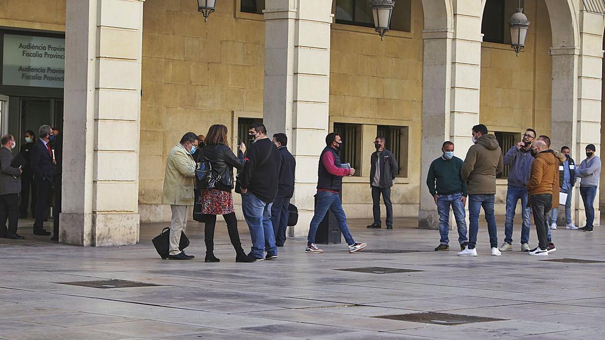 Algunos de los acusados hablan con sus abogados, ayer frente la Audiencia, antes del juicio.