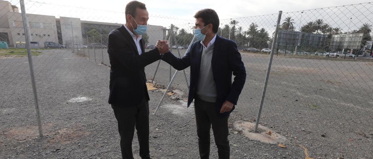 El alcalde de Elche, Carlos González, y el presidente de la Diputación, Carlos Mazón, estrechan sus manos en una visita en diciembre a los terrenos donde se pretende ubicar el palacio de congresos.