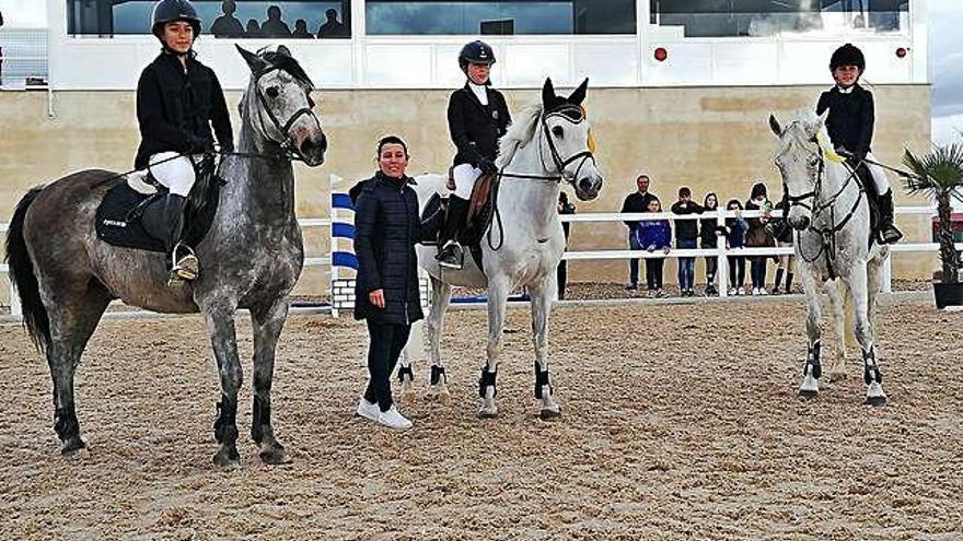 Tres de los participantes en el concurso hípico, recibiendo sus distinciones.