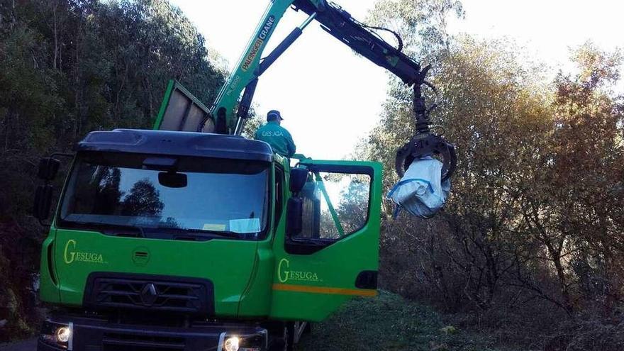 Un camión-grúa carga algunos de los restos arrojados entre Cuntis y A Estrada.  // FdV