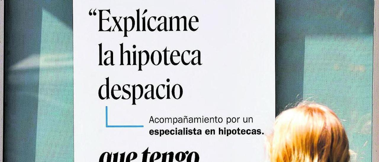 Una mujer lee el cartel publicitario sobre hipotecas de una entidad financiera, en una imagen de archivo.