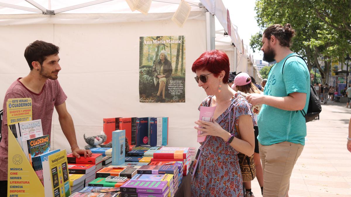 Una dona mira llibres en un estand del mercat d'editorials situat a la Rambla de Santa Mònica en motiu de la primera edició de la Vila del Llibre a Barcelona