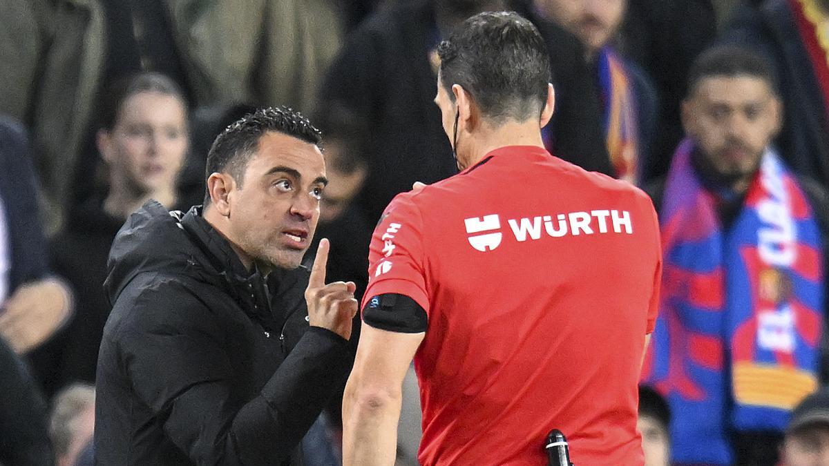 Xavi discute con el árbitro Martínez Munuera tras ser amonestado durante las semifianles de Copa del rey contra el Real Madrid
