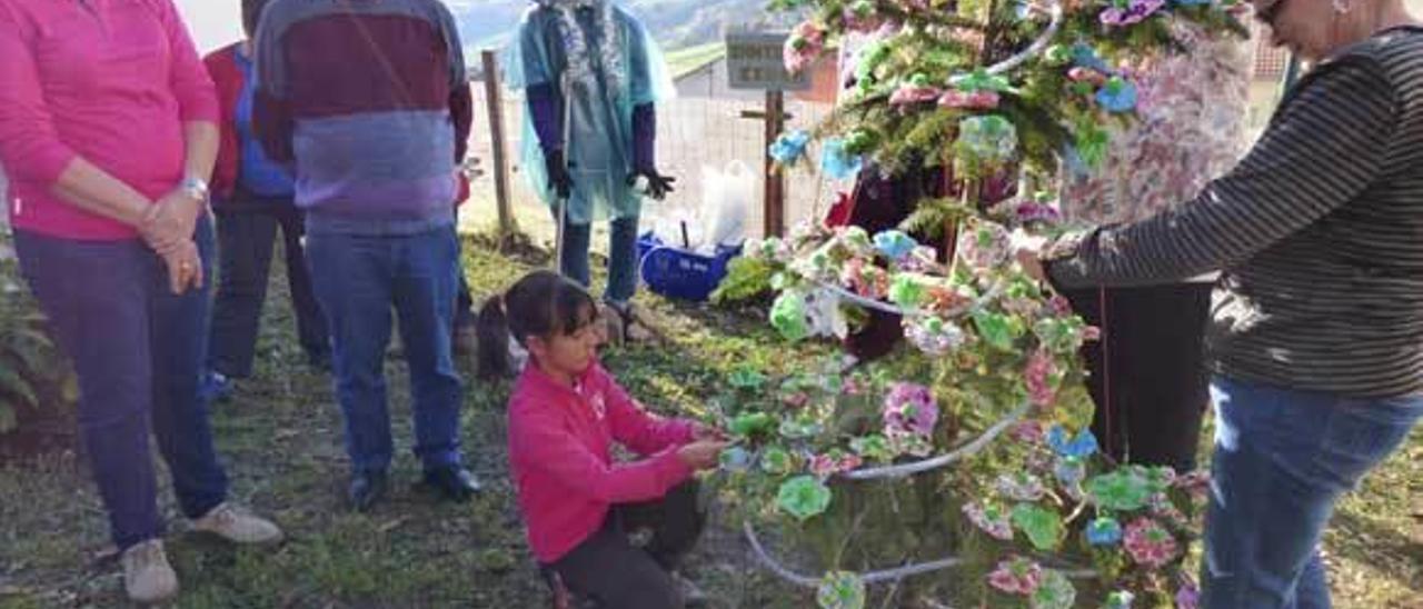 Jimena Suárez, Mari Paz Gayo y Ana Valdés decoran el árbol ante la mirada de Aurora Pérez y Carlos Fernández.