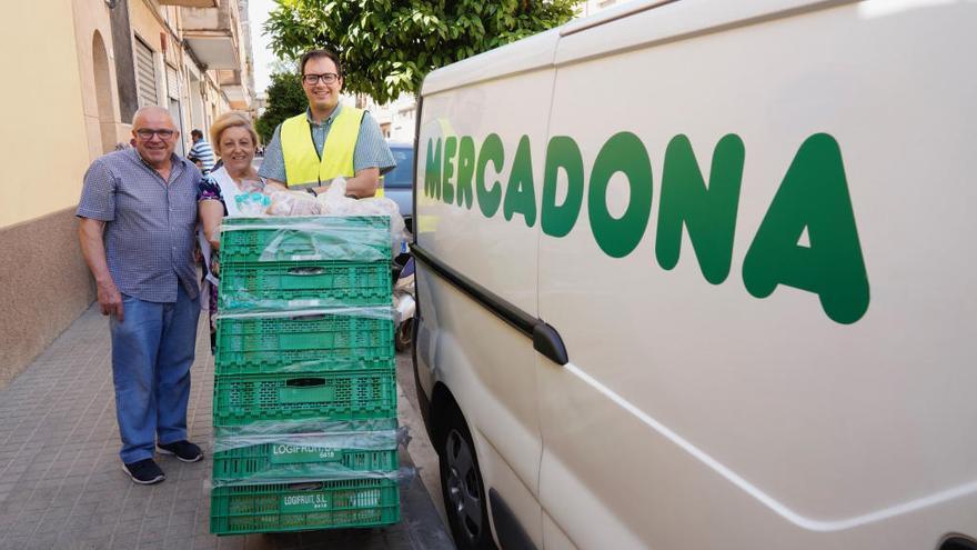 El repartidor de Mercadona prepara el transporte de alimentos junto al presidente del comedor, Javier Bertó.