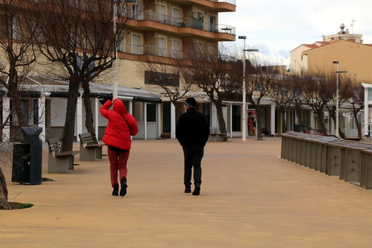 Una parella passejant a l'Escala, malgrat el vent