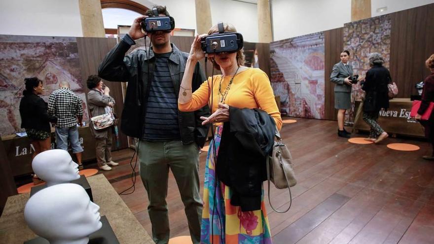 Dos visitantes usan las gafas de realidad virtual para contemplar las pinturas del templo perrománico en su estado original, ayer, en el RIDEA.