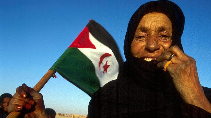 Una mujer porta una bandera saharaui en los campamentos de refugiados de Tinduf, en Argelia.