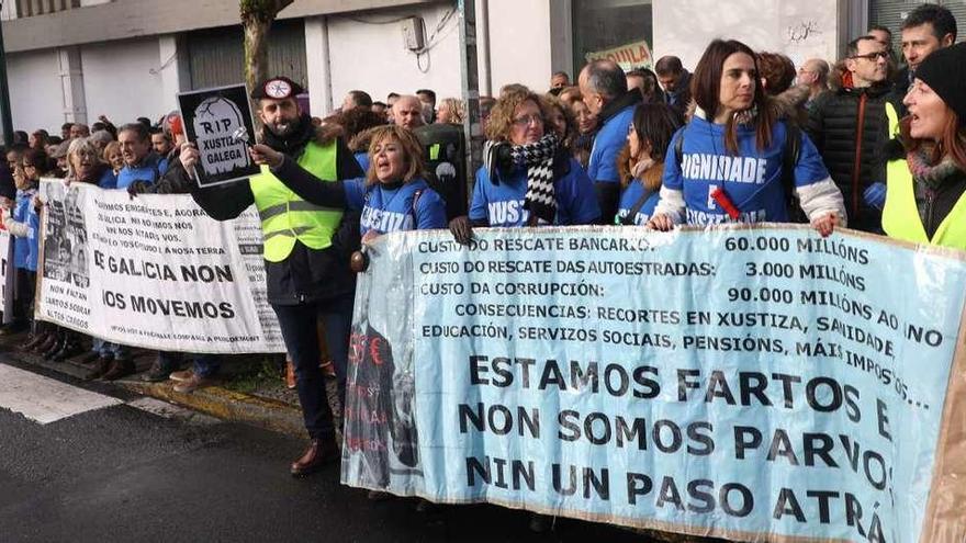 Protesta a las puertas del Parlamento  |  Un centenar de trabajadores de justicia se concentró ante la Cámara gallega mientras Rueda comparecía para exigir la mejora de sus condiciones. &quot;¡Rueda, escucha, estamos en lucha!&quot; y &quot;¡Ni un paso atrás!&quot; fueron algunos de los lemas que entonaron, informa Europa Press. También hicieron sonar sus silbatos y bocinas con carteles en los que denunciaban la &quot;discriminación en la justicia gallega&quot;, en alusión a trabajadores de otras comunidades con competencias en la materia.