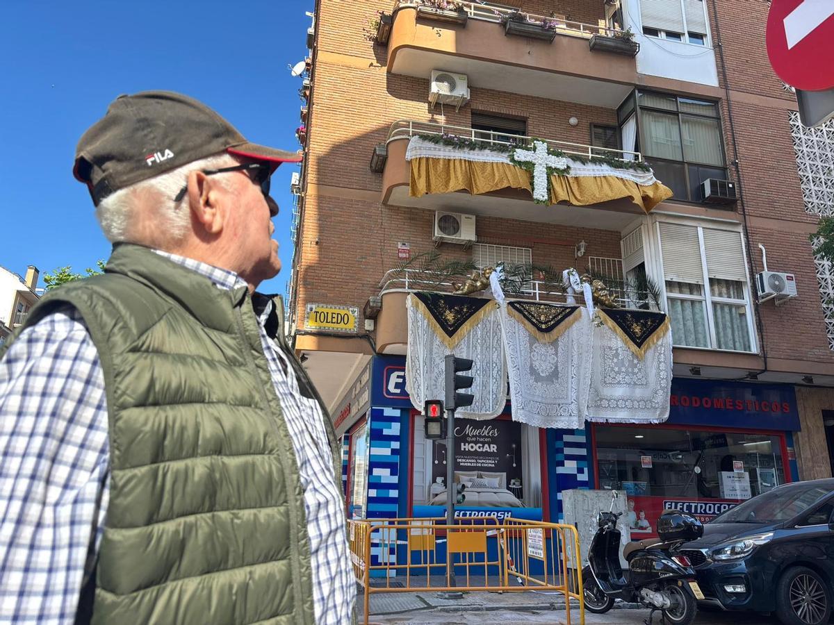 Un vecino de San Roque observa la Cruz de Mayo instalada por Papy en la calle Toledo de Badajoz.