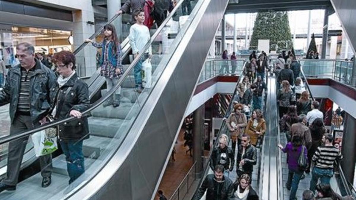 Decenas de ciudadanos pasean por el centro comercial La Maquinista.