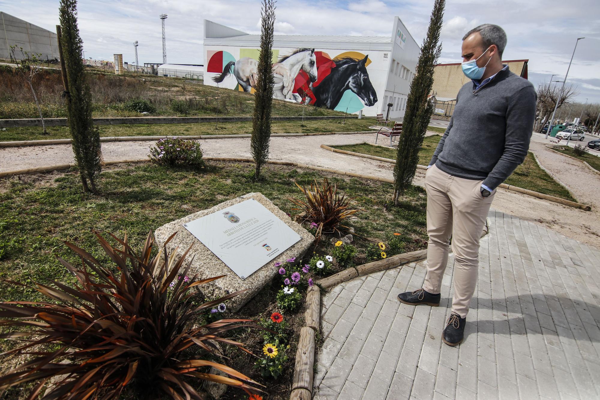 El alcalde de Arroyo de la Luz, Carlos Caro Domínguez, observa la placa de homenaje a los fallecidos por la pandemia en el bautizado como Parque del Recuerdo, a las afueras de la localidad.