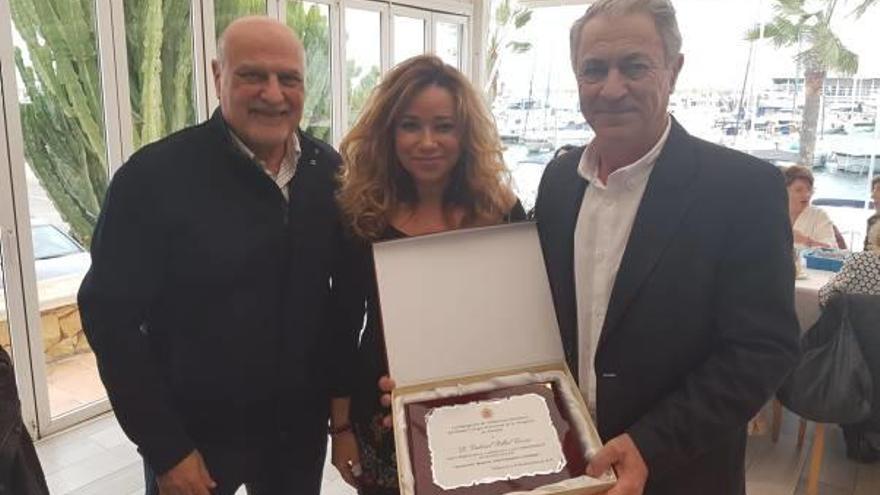 Gabriel Fillol muestra la placa junto a Fernando Candela y Carmen Díez.