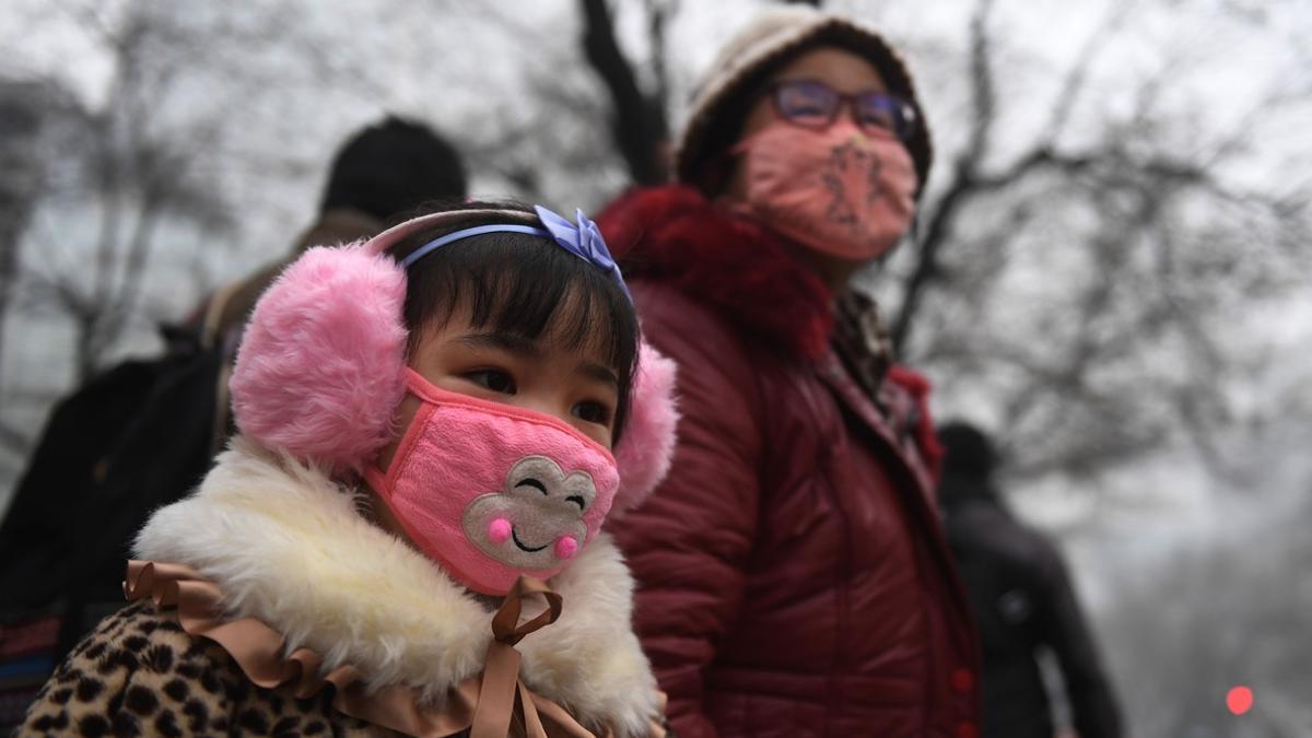 Una madre y su hija, por las contaminadas calles de Shijiazhuang, al norte de China, este miércoles, 21 de diciembre.