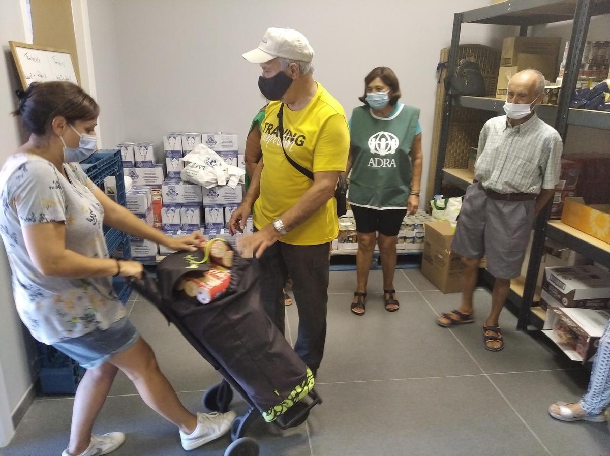 Los voluntarios reparten alimentos a familias necesitadas, en coordinación con los servicios sociales municipales.