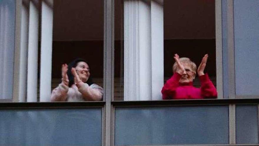 Vecinos de Vigo, ayer, aplaudiendo desde sus ventanas en el homenaje diario a los trabajadores sanitarios. // Ricardo Grobas