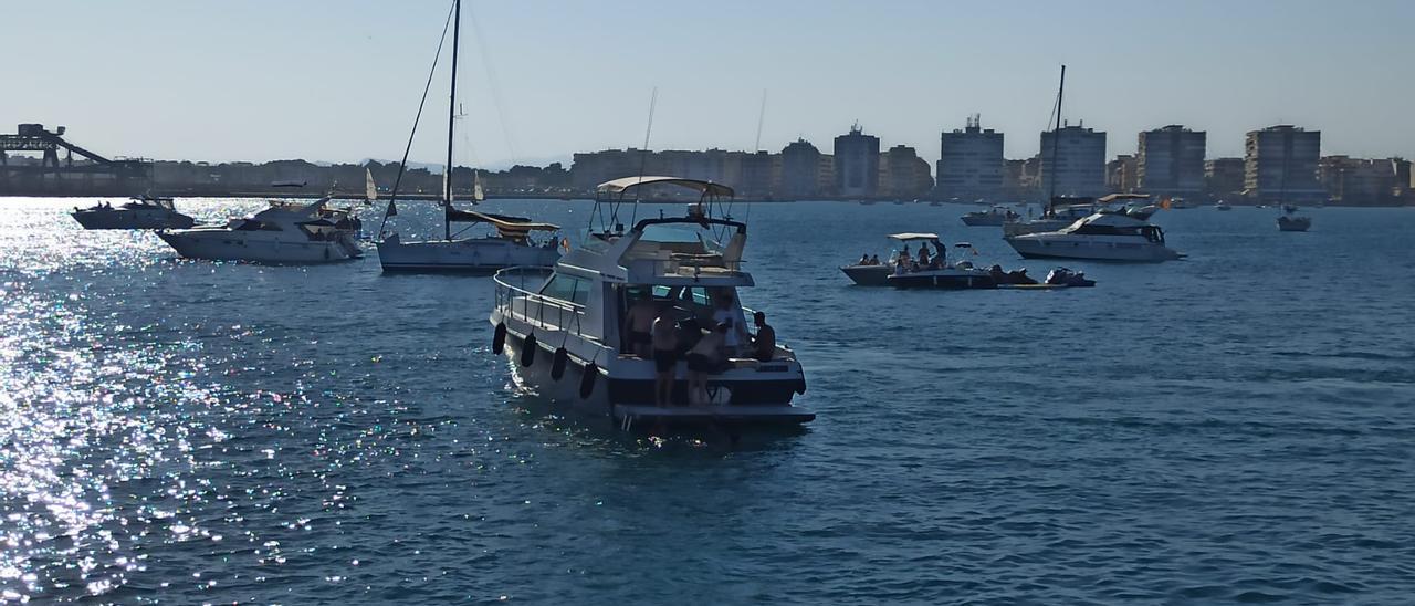 Embarcaciones fondeadas en la bahía de Torrevieja, motos de agua y baños. Actividades prohibidas dentro de la dársena.