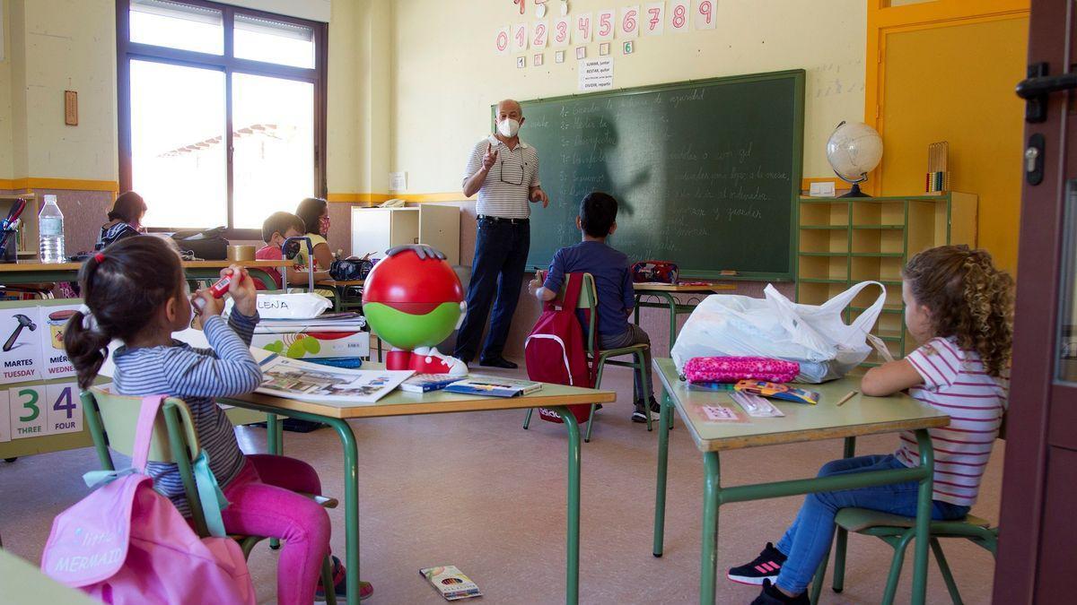 Unos niños atienden a su profesor en una escuela rural de Arrabalde (Zamora).