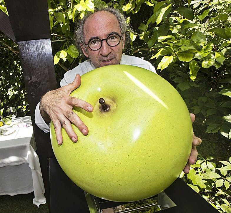 José Antonio Campoviejo, en El Corral del Indianu, con una manzana decorativa; a la izquierda, Toño Villa poda sus tomateras en su finca de Nueva. | Miki LópezJosé Antonio Campoviejo, en El Corral del Indianu, con una manzana decorativa. | Miki López