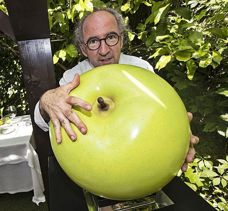 José Antonio Campoviejo,  en El Corral del Indianu, con una manzana decorativa; a la izquierda, Toño Villa poda sus tomateras  en su finca de Nueva. | Miki LópezJosé Antonio Campoviejo, en El Corral del Indianu, con una manzana decorativa. | Miki López