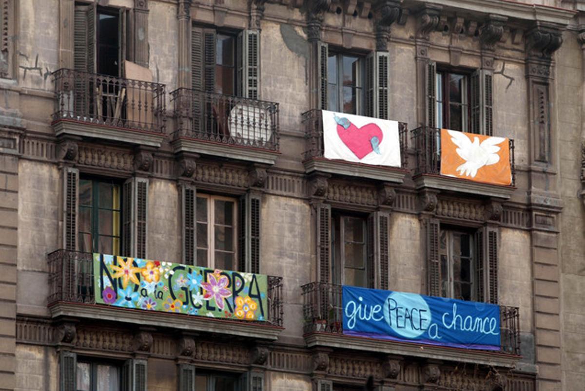Los balcones de la capital catalana también mostraban pancartas antibelicistas, antes, durante y después de la marcha masiva.