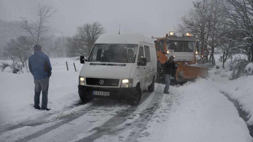 Una máquina quitanieves despeja una carretera junto a un vehículo atrapado, ayer, en Montederramo (Ourense). // Brais Lorenzo