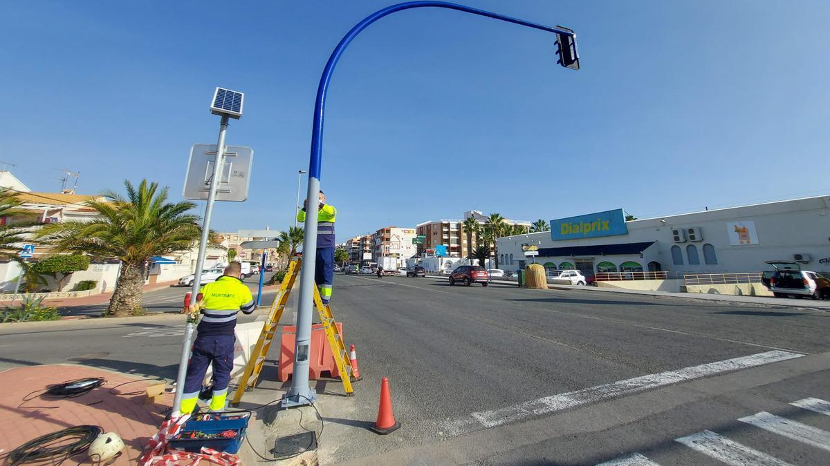 Operarios instalan un semáforo en la avenida de Desiderio Rodríguez a la salida de Torrevieja por el sur