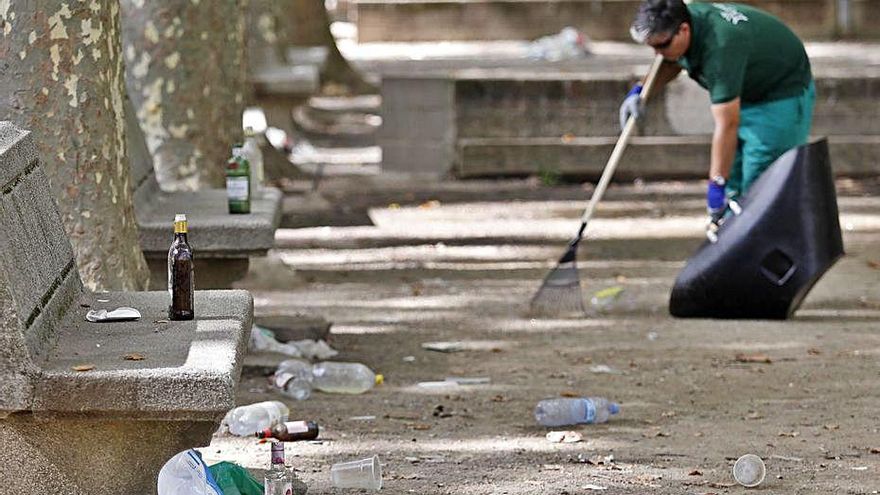 Treballadors netejant les restes del «botellon» de dijous. | ANIOL RESCLOSA Treballadors netejant les restes del «botellon» de dijous. | ANIOL RESCLOSA