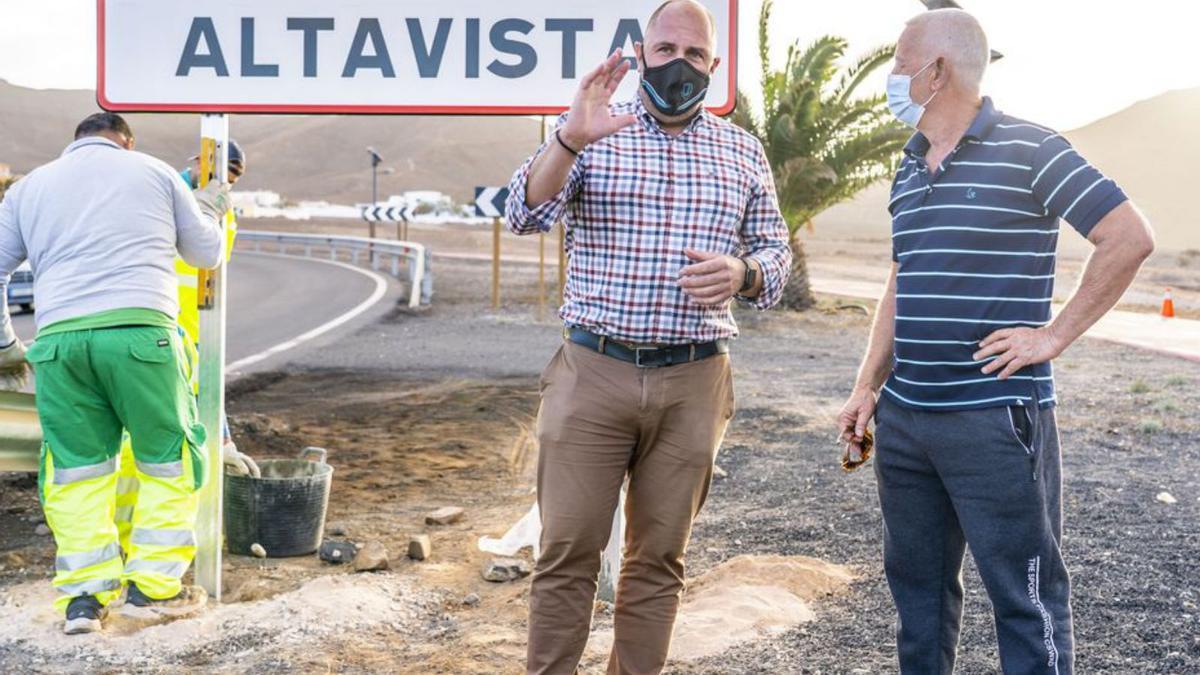 Sergio Lloret dialoga con un vecino en el acto de colocación del cartel. |