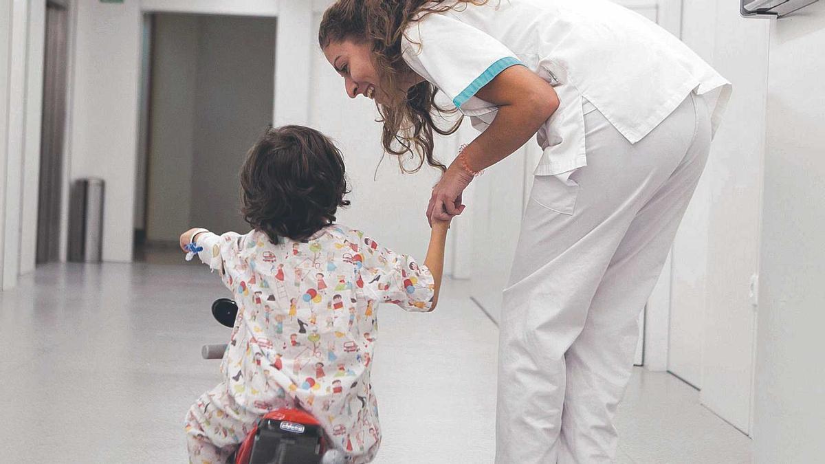 Un nen hospitalitzat amb una infermera en un centre de Barcelona.