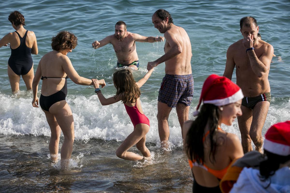 Una família es banya a la platja de Sant Sebastià.