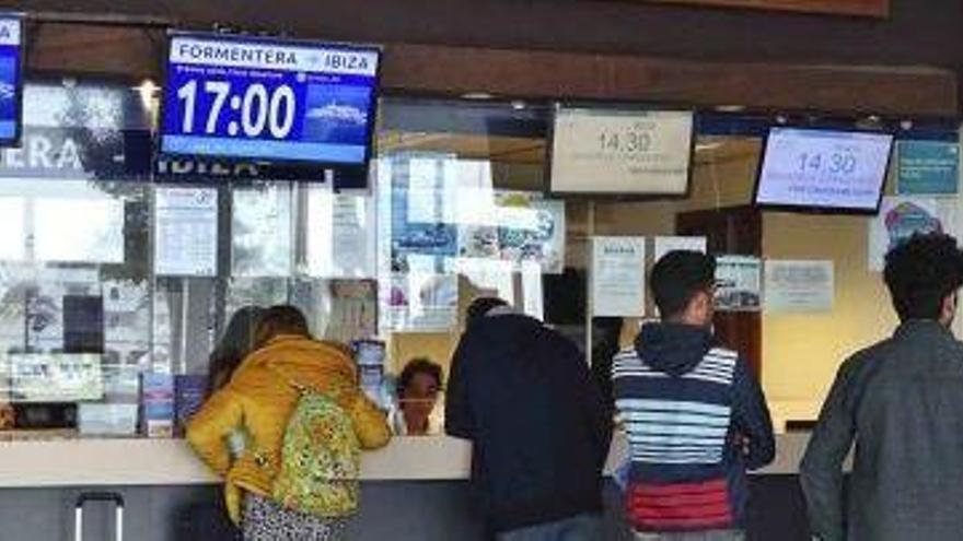 Un grupo de pasajeros ante las taquillas de navieras en la estación marítima de la Savina.