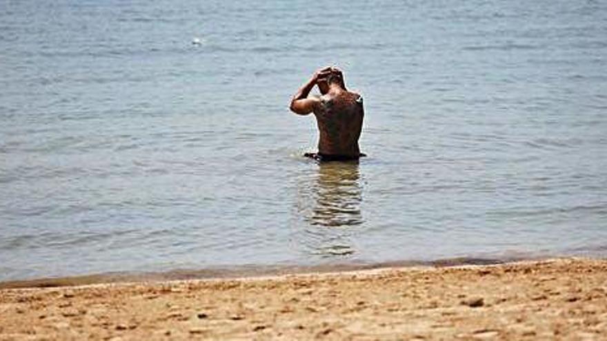Un hombre se refresca en la playa en Sant Antoni del intenso calor hace unos días.