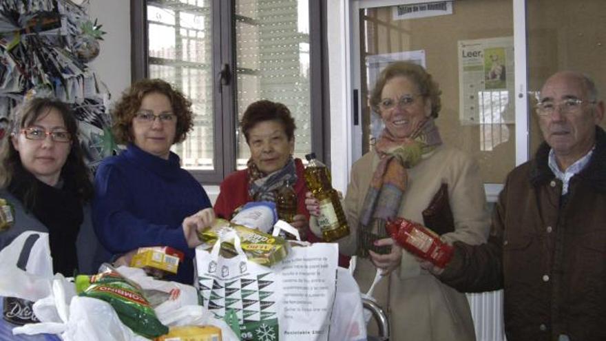 Varias personas, ayer, entregan alimentos en el IES Fuentesaúco.