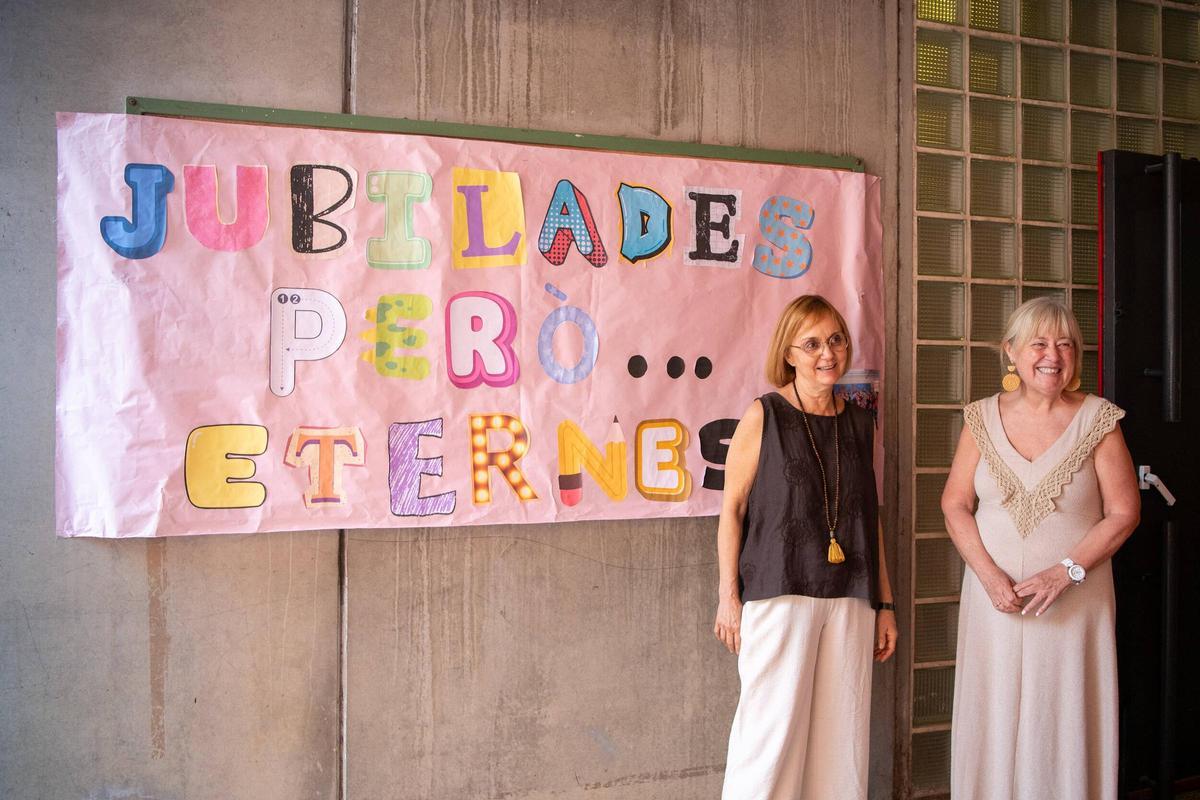 Conxita y Alícia, frente al póster que le hicieron sus compañeros de trabajo.