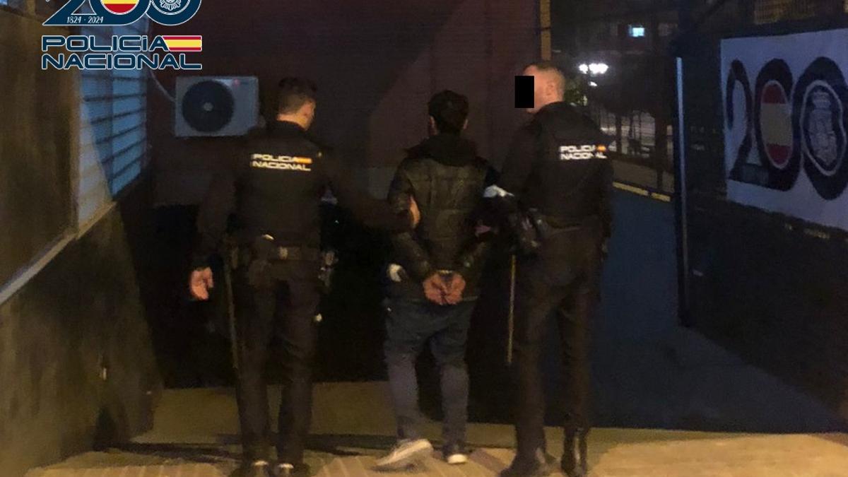 Dos agentes de la Policía Nacional con el detenido.