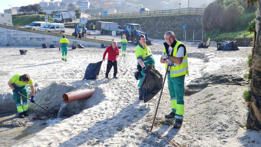 Operarios de limpieza poniendo a punto la playa de Caión, en A Laracha, para la Semana Santa