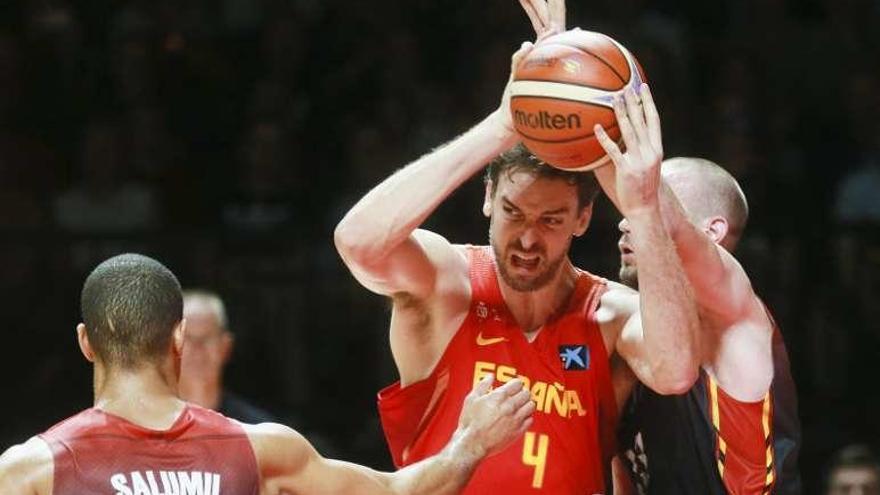 Pau Gasol agarra el balón ante la oposición de un rival. // Efe