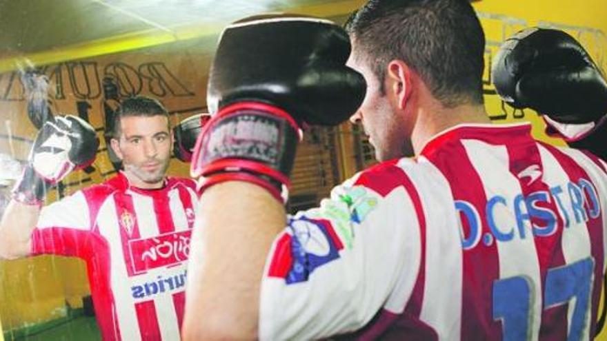 Alejandro Pereira posa frente a un espejo del Centro Deportivo Gijón con la camiseta rojiblanca de Diego Castro que utiliza en los combates.