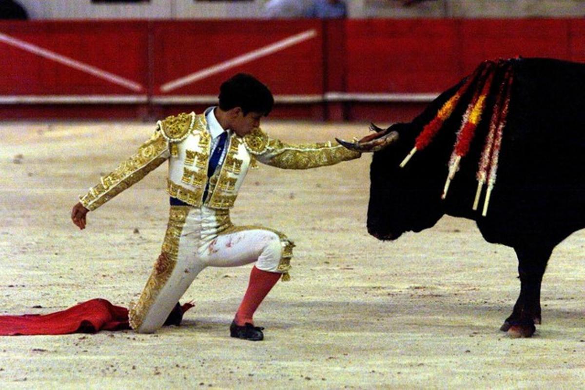 El torero Julián López ’El Juli’ s’agenolla davant el seu segon toro durant una corrida celebrada a Nimes, França, el 2001. El torero Julián López ’El Juli’ s’agenolla davant el seu segon toro durant una corrida celebrada a Nimes, França, el 2001.