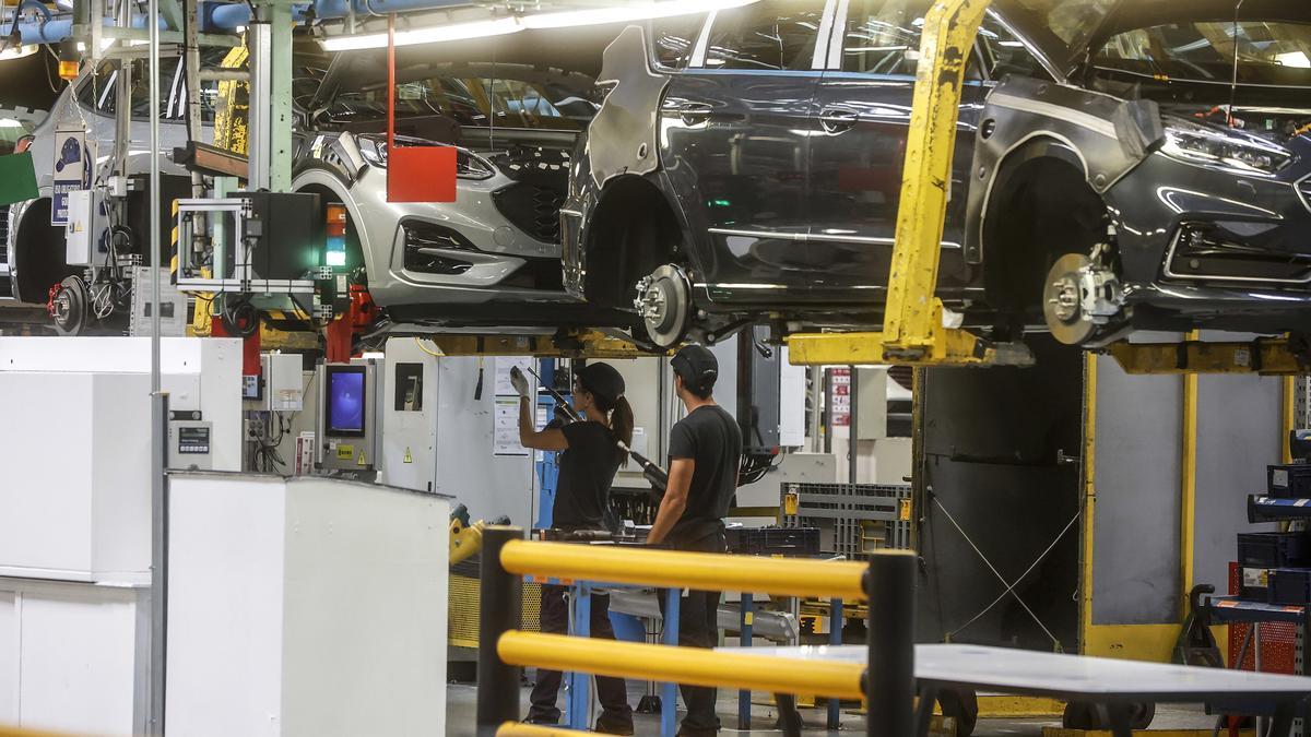 Dos trabajadores en una planta de fabricación de automóviles.