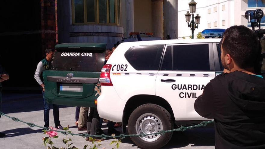 Agentes de la Guardia Civil cargan su vehículo con material del registro.