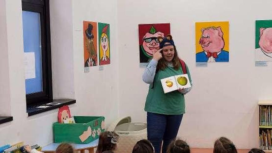 La mascota &quot;Leo&quot;, ayer, contando un cuento a un grupo de niños en la biblioteca de Mieres.