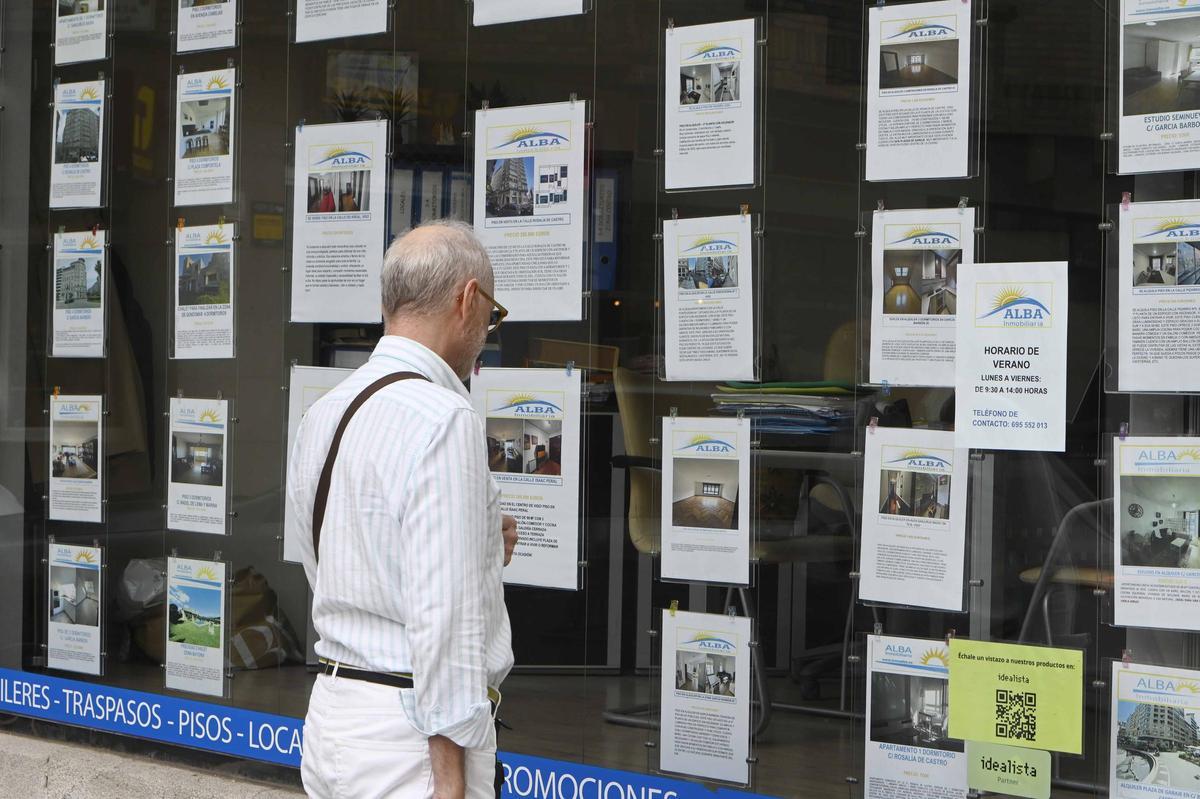 Un señor observando los anuncios de una inmobiliaria de Vigo.