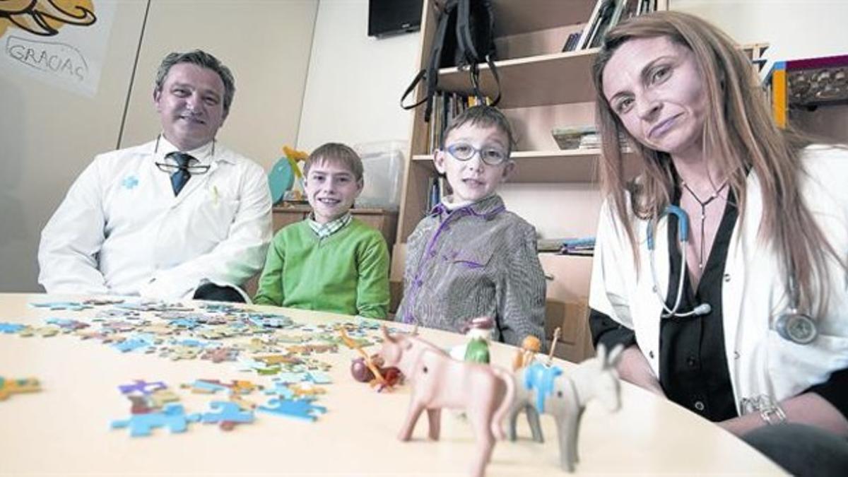 El cirujano Javier Bueno, junto a Álex Curero (jersey verde), Álex Gil, otro niño operado, y la doctora Susana Recillas, en el Hospital del Vall d'Hebron.