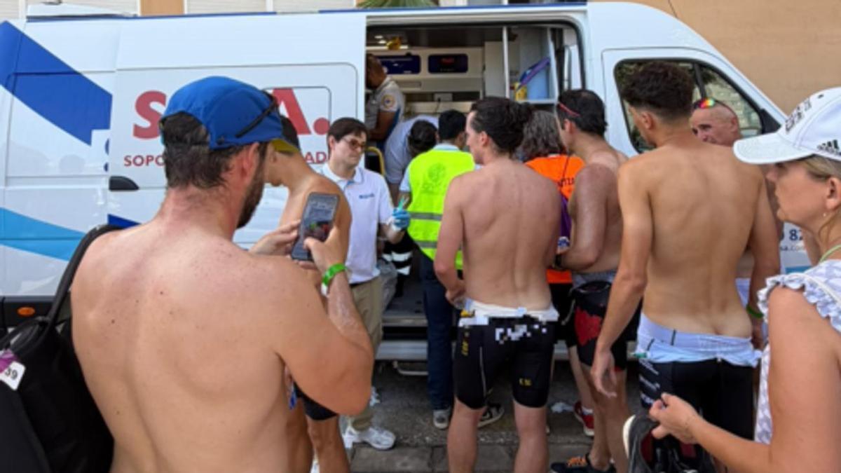 Varios triatletas acuden a las ambulancias para ser atendidos tras las picaduras de las medusas en el triatlón de Tavernes