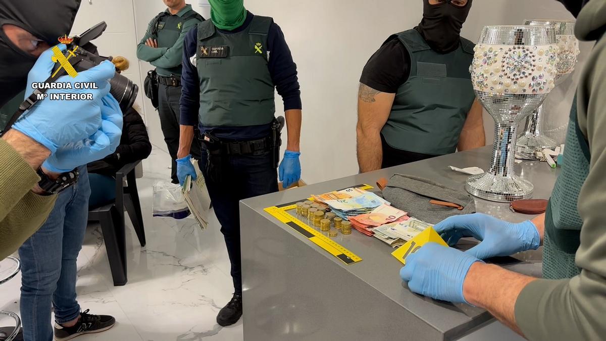 Agentes junto al dinero, joyas y droga intervenidos en la intervención de la Guardia Civil en Palma del Río.